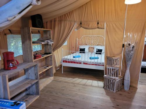 Saint-Martin-des-BesacesTente Lodge Safari的帐篷内一间卧室,配有一张床