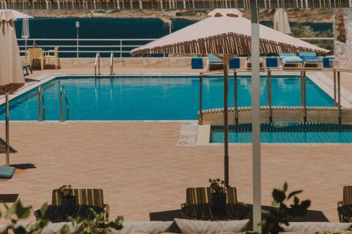 卡拉塔斯克塔维塔利斯酒店的一个带椅子和遮阳伞的游泳池