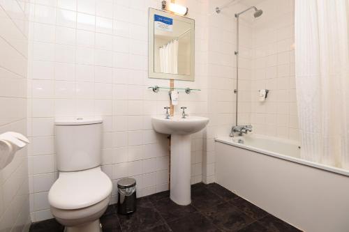 埃克塞特White Hart, Exeter by Marston's Inns的浴室配有卫生间、盥洗盆和浴缸。