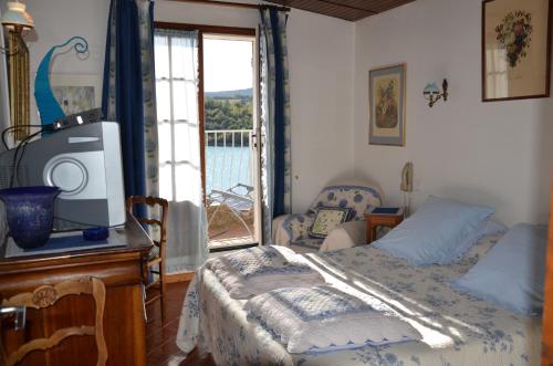博迪昂湖泊旅馆的一间卧室设有一张床、一台电视和一个窗口。