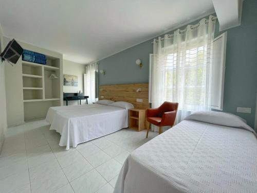 巴雷罗斯Hotel Amadora - Admite mascotas的一间卧室设有两张床、一把椅子和一个窗户。