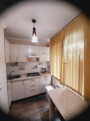 奇姆肯特Family apartment 7的厨房配有白色橱柜和桌子