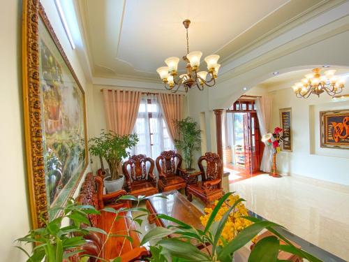 大叻Jolie Maison Đà Lạt的一间种植了植物和吊灯的客厅