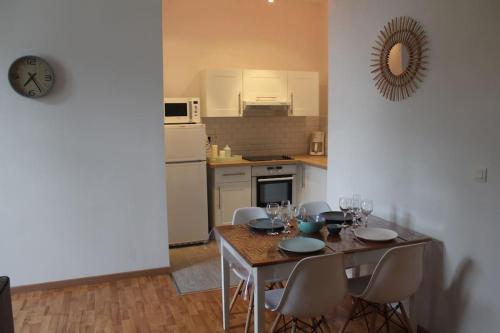 索米尔Appartement calme proche de la Loire的厨房配有桌椅和酒杯
