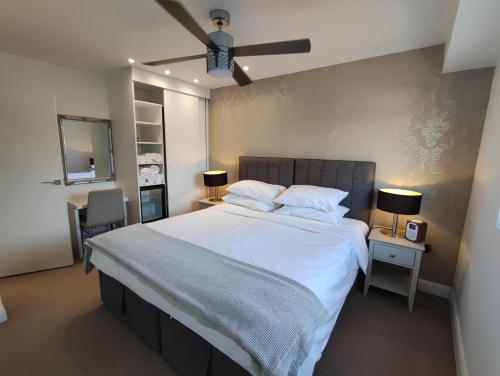 伦敦Modern 2 Bedroom Flat with private outdoor terrace的卧室配有一张白色大床和吊扇