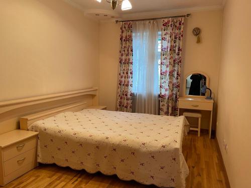 塔什干4-room apartment in the center of Tashkent的一间卧室配有一张床、一个梳妆台和一扇窗户。