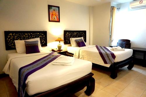 清迈旺布拉帕大酒店的酒店客房设有两张床和窗户。