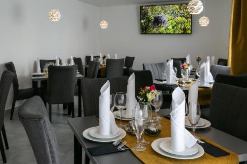 利贝雷茨Wellness Hotel Edelweiss的用餐室配有桌椅和白色餐巾