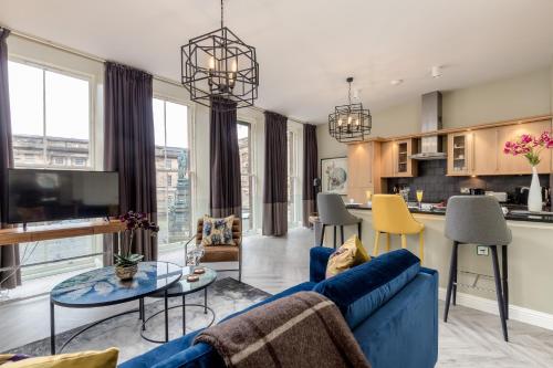 爱丁堡ALTIDO Luxury flats in Old Town, right on Royal Mile的一间带蓝色沙发的客厅和一间厨房