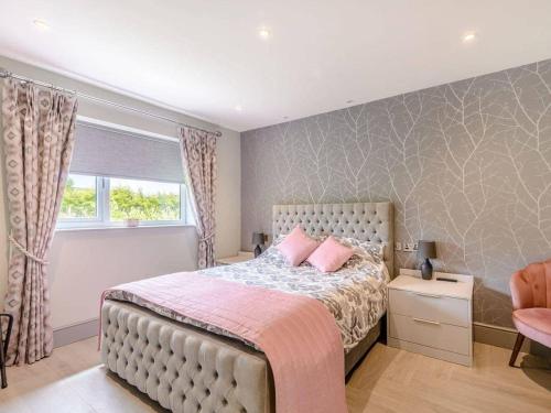 布莱克本Willows Cottage的一间卧室配有带粉红色枕头的床和窗户。