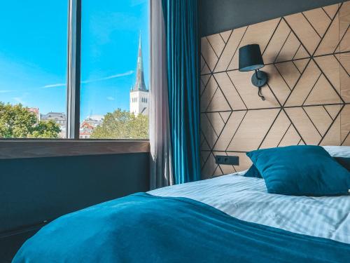塔林卡尔沃温泉酒店&水上乐园的一间卧室设有一张床,窗户设有教堂