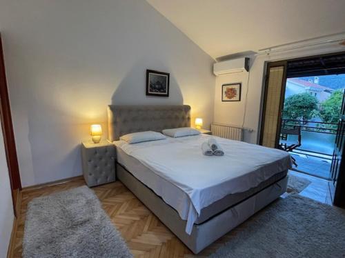布德瓦Apartment Ruzica的一间卧室配有一张带两盏灯的床和一个阳台