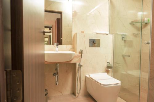 科钦THE RUNWAY HOTEL的浴室配有卫生间、盥洗盆和淋浴。