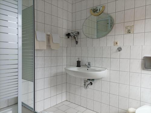 AltenhofPension Landgasthof Darzer Eck的白色瓷砖浴室设有水槽和镜子