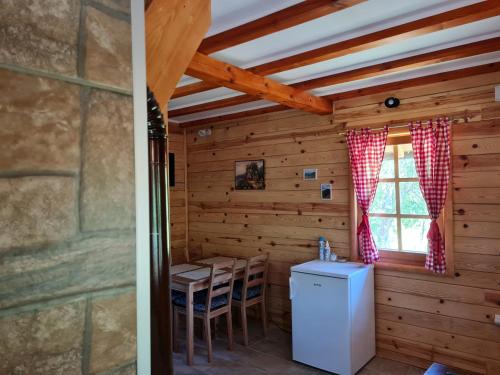 莫克拉戈拉Guest House Rankić的小木屋内的厨房配有桌子和冰箱
