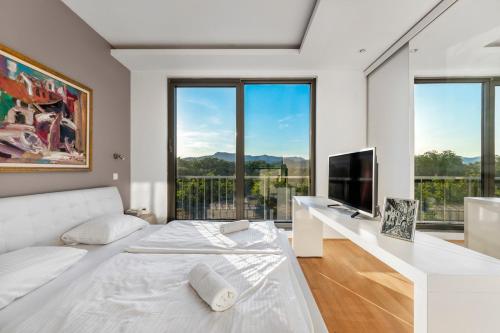 马里博尔Contemporary apartment with rooftop terrace in Maribor的白色卧室配有白色的床和电视