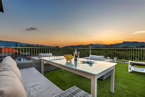 马里博尔Contemporary apartment with rooftop terrace in Maribor的庭院配有白色的桌子和椅子,位于草地上