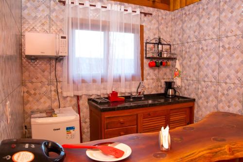 维奥康德马奥Chales Encanto do sol的厨房设有水槽、窗户和桌子