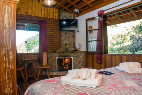 维奥康德马奥Chales Encanto do sol的一间卧室设有壁炉和带毛巾的床。