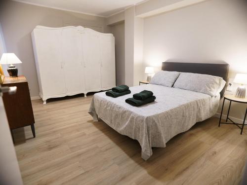 卡斯特利翁-德拉普拉纳II Apartamento moderno y céntrico en Castellón的一间卧室配有一张带两张绿毛巾的床