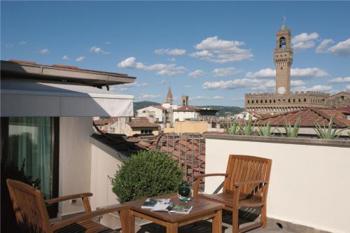 佛罗伦萨艺术画廊酒店 - 朗伽诺酒店集团的阳台配有桌椅和钟楼