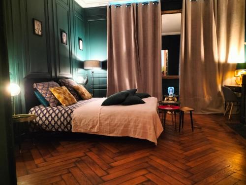 南希Nancy Vieille Ville Stanislas的一间卧室设有绿色的墙壁和一张带枕头的床