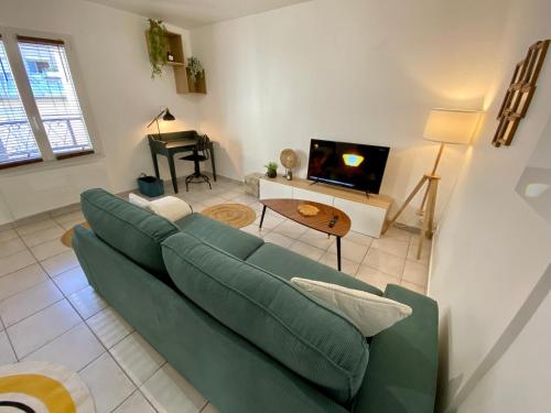 蒙雷里Superbe appartement 2 pièces, plein centre ville.的客厅配有绿色沙发和电视