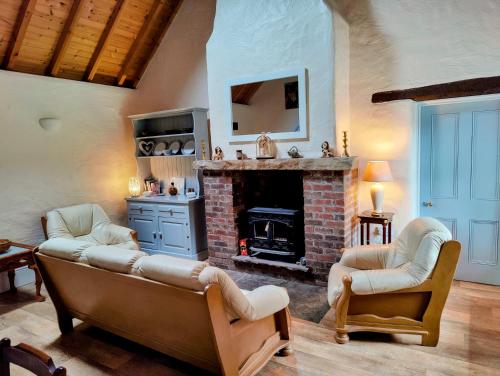 ManorhamiltonCarraun Cottage的带沙发和壁炉的客厅