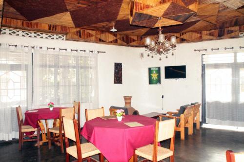 KinigiLa paillotte gorilla place kinigi的一间带桌椅和吊灯的用餐室