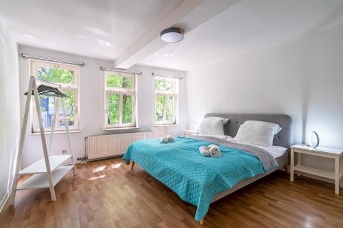 弗里德贝格Stylische 2-Zimmer Wohnung - Balkon - Parkplatz - Smart TV - Arbeitsplatz的卧室配有一张睡床,床上有两只填充的动物,放在蓝色的毯子上