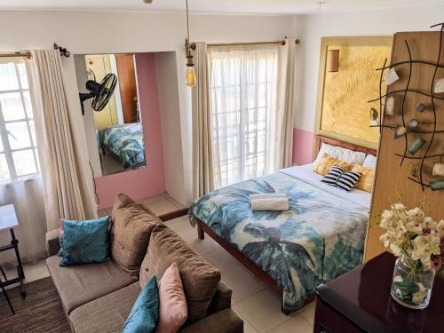 内罗毕Home and Away Cozy Studio Apartment number 407的一间卧室配有一张床和一张沙发