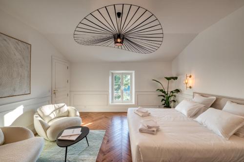 Le BarrouxL'Iris de Suse的客厅配有一张大床和一把椅子