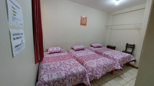 纳斯卡JUMANA的一间卧室配有两张带粉红色毯子的床