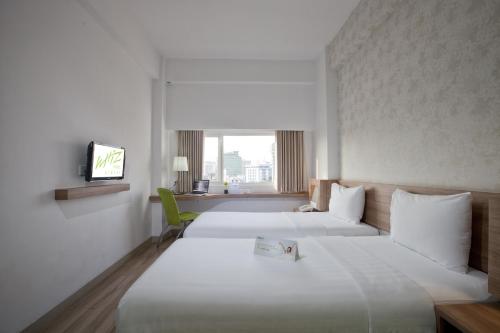 雅加达雅加达奇基尼呼啸酒店的酒店客房设有两张床和电视。