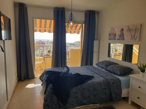 阿罗纳Preciosas habitaciones en la casa de May的一间卧室设有一张床和一个大窗户