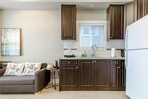 温哥华Rare Find Exquisitely New Quiet & Safe Skytrain Home的带沙发和白色冰箱的厨房