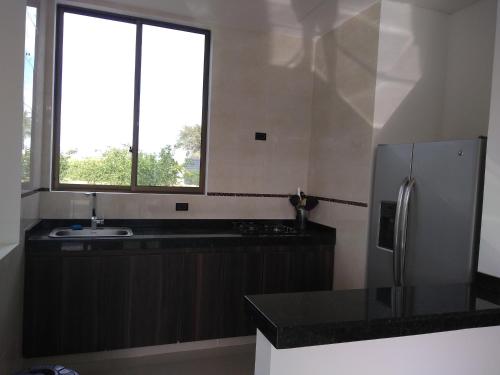 吉拉尔多特VILLA SAMARI 2 Casa campestre con piscina privada的厨房配有冰箱和窗户。