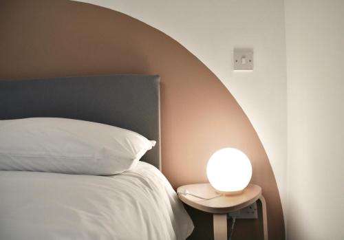 爱丁堡Roost Hill Guest House - Free Parking的一张带白色枕头的床和边桌边的灯