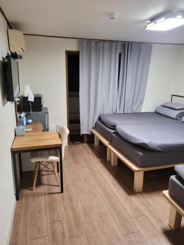 首尔弘大爱博2号旅馆的一间卧室配有一张床、一张桌子和一张书桌