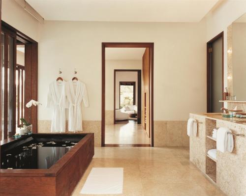 帕洋安COMO Shambhala Estate的带浴缸和镜子的浴室