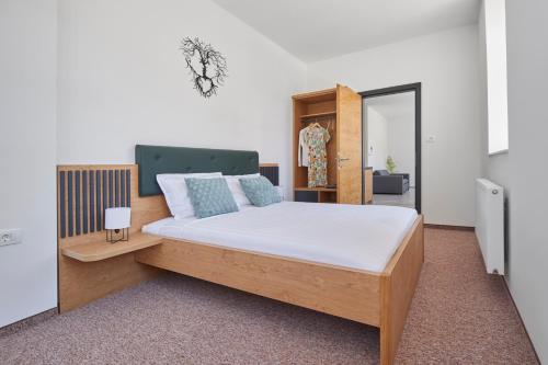 科斯塔涅维察Ob Krki Apartments的一间卧室配有一张带木制床头板的床