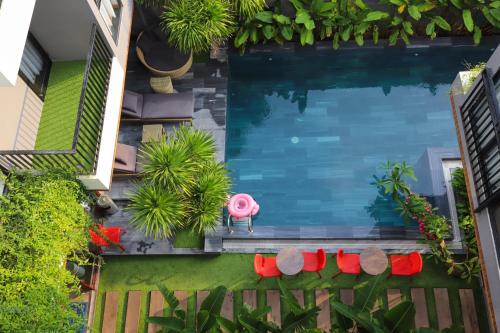 岘港K-House vs Apartment的享有游泳池的顶部景色,设有红色椅子和植物