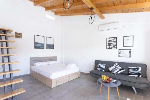 阿特米达Spitakia-Cozy & Comfy Apartments 10minutes from the airport的一间卧室配有一张床、一张沙发和一张桌子