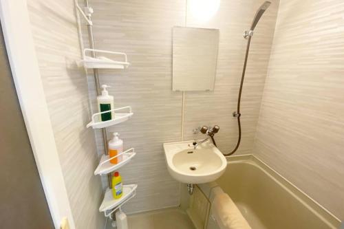 Shimeラ・ポート空港前101的浴室配有盥洗盆和浴缸。