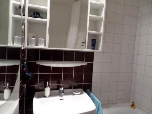 格吕克斯堡Meeresbrise Schausende的一间带水槽和白色橱柜的浴室