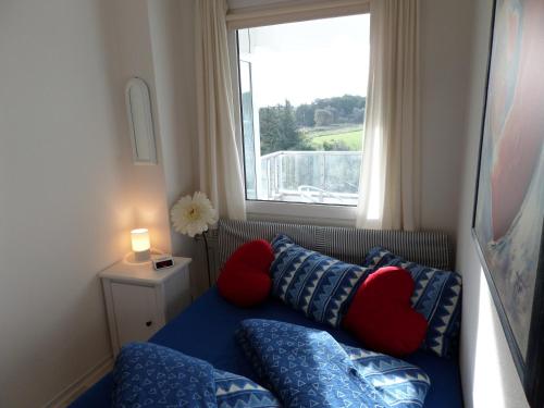 格吕克斯堡Meeresbrise Schausende的客房设有带枕头的沙发和窗户。