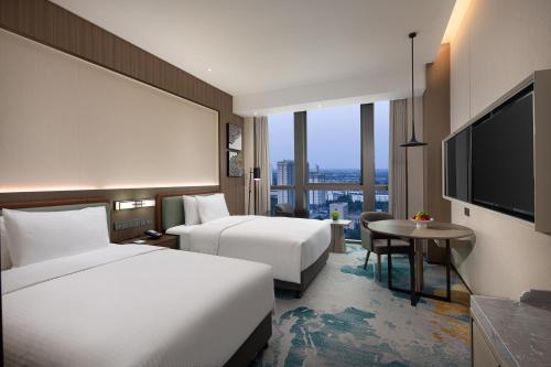 定州定州香江万达锦华酒店的酒店客房设有两张床和一台平面电视。