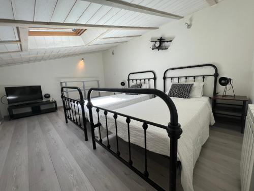 罗什福尔T3 COSY MAISON DE VILLE TERRASSE AU CALME的一间卧室配有一张黑色的床和一台电视。