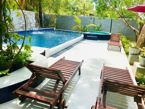 哈伯勒内Bangalawa Resort的一个带两把椅子的庭院和一个游泳池