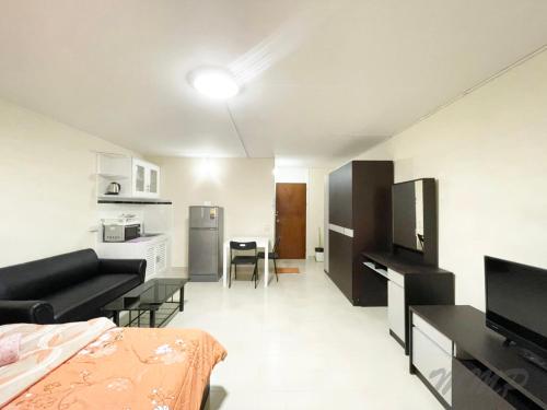 Thung Si Kanป็อปปูล่าคอนโด เมืองทองธานี ใกล้ Impact 酒店 公寓的一间带一张床的客厅和一间带沙发的厨房
